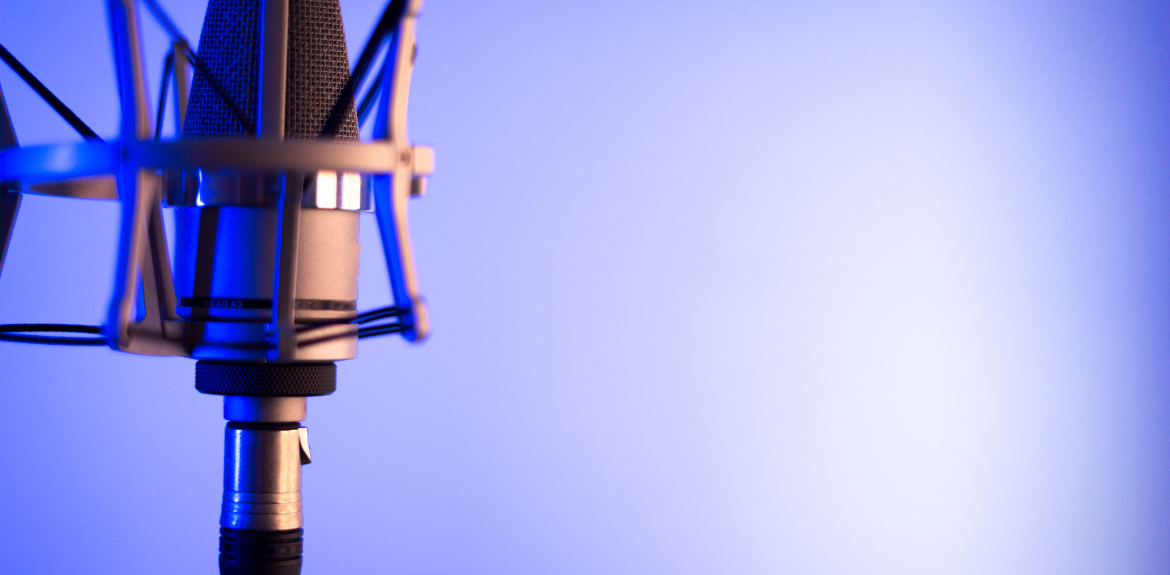 Close up of a microphone against a light vibrant blue background