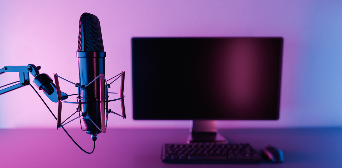 Microphone attached to a wall and a monitor against a purple background.