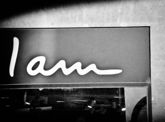 The phrase "I am" in white lettering appears against various shades of gray.